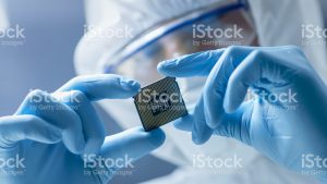 Engineer examining a microchip with gloves